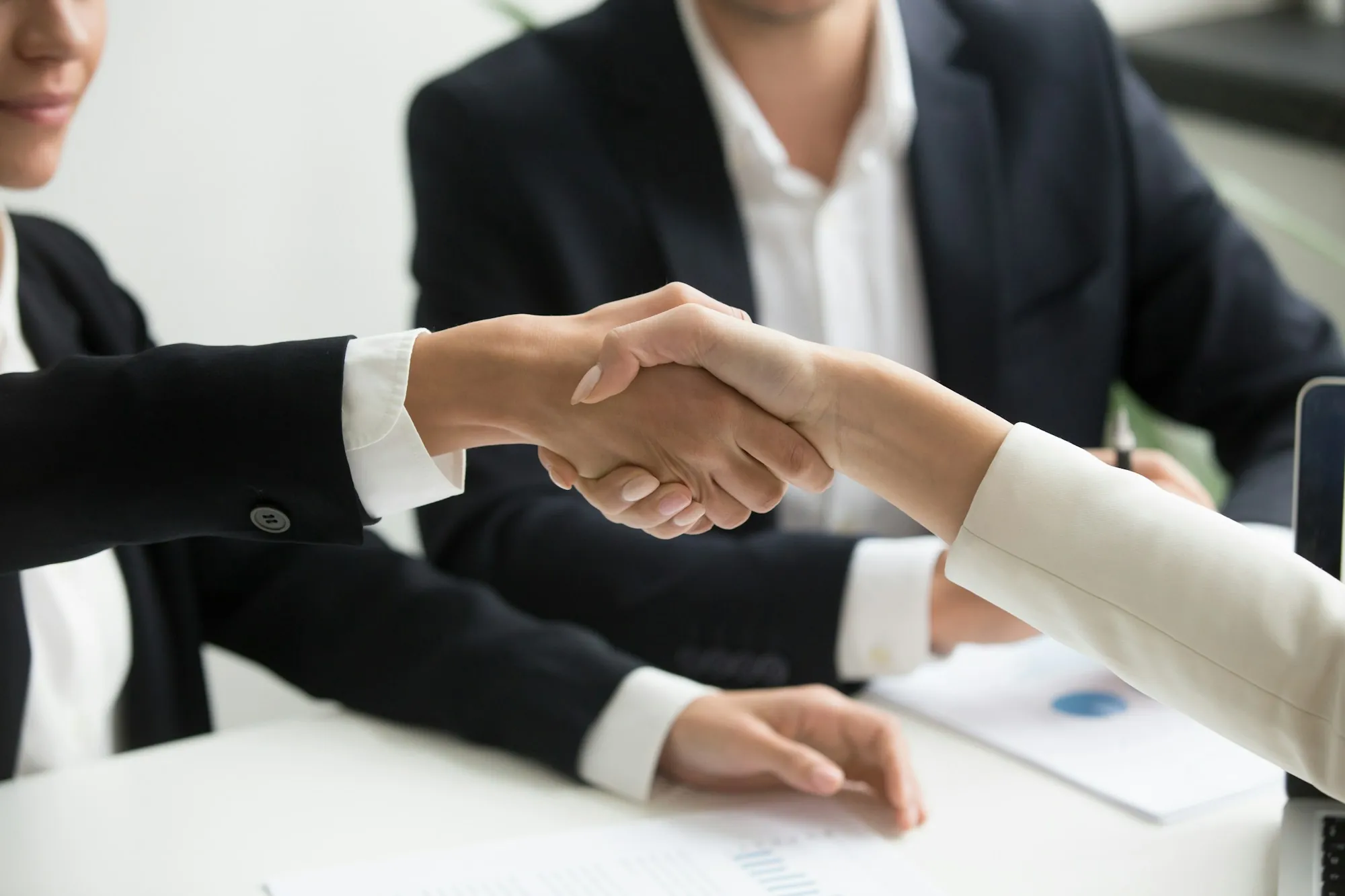 Handshake across a table at a business meeting