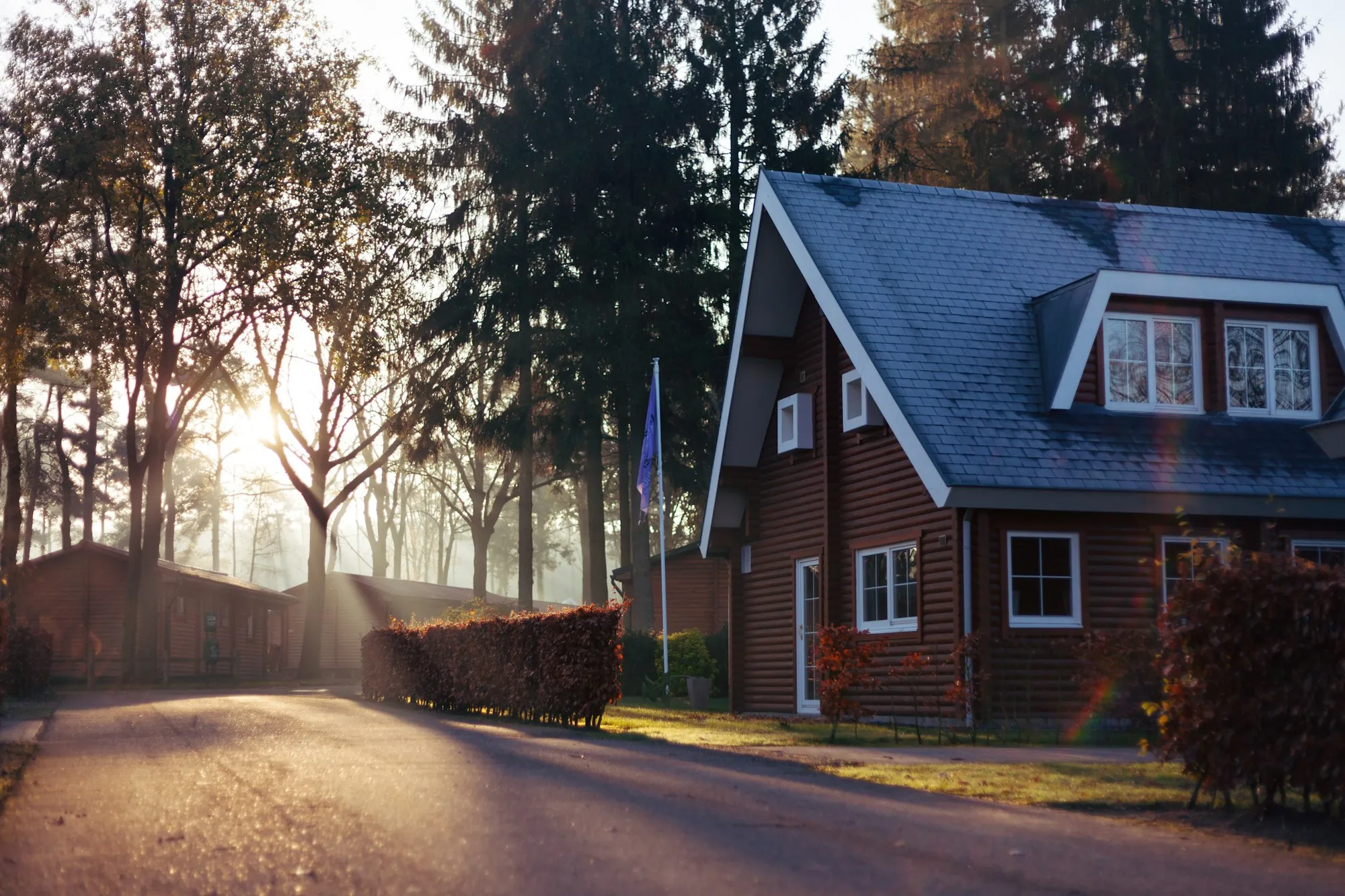 Brick cottage with a dark shingle roof and dormers, the kind of attic that needs balanced roof ventilation in Suwanee summers